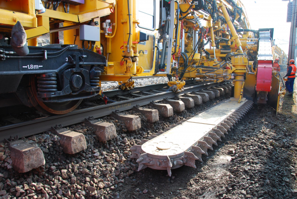 The excavating unit (excavating sword) with the horizontally circuiting excavating chain is slewed under the skeleton track either from the left or the right hand side.