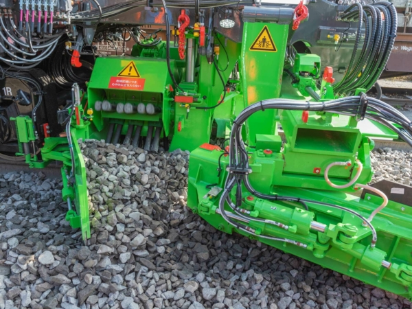 Transverse brushes in the frontal plough - crosswise transport and placement of ballast in the inner tamping zones